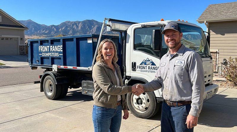 A homeowner and a Front Range Dumpsters driver beside his roll-off truck